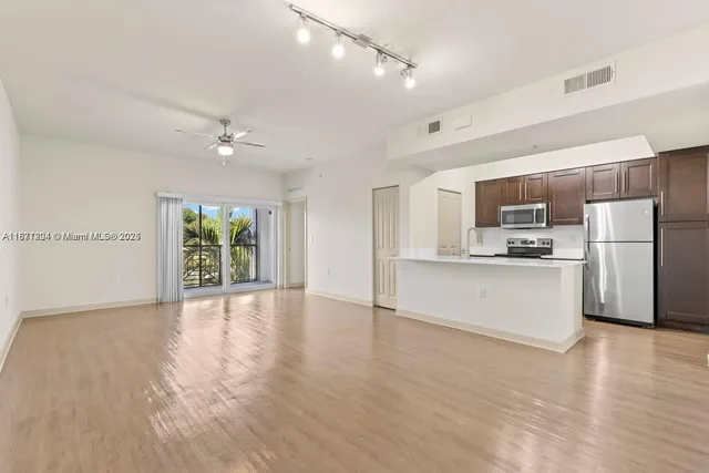 a view of kitchen with stainless steel appliances refrigerator oven and cabinets