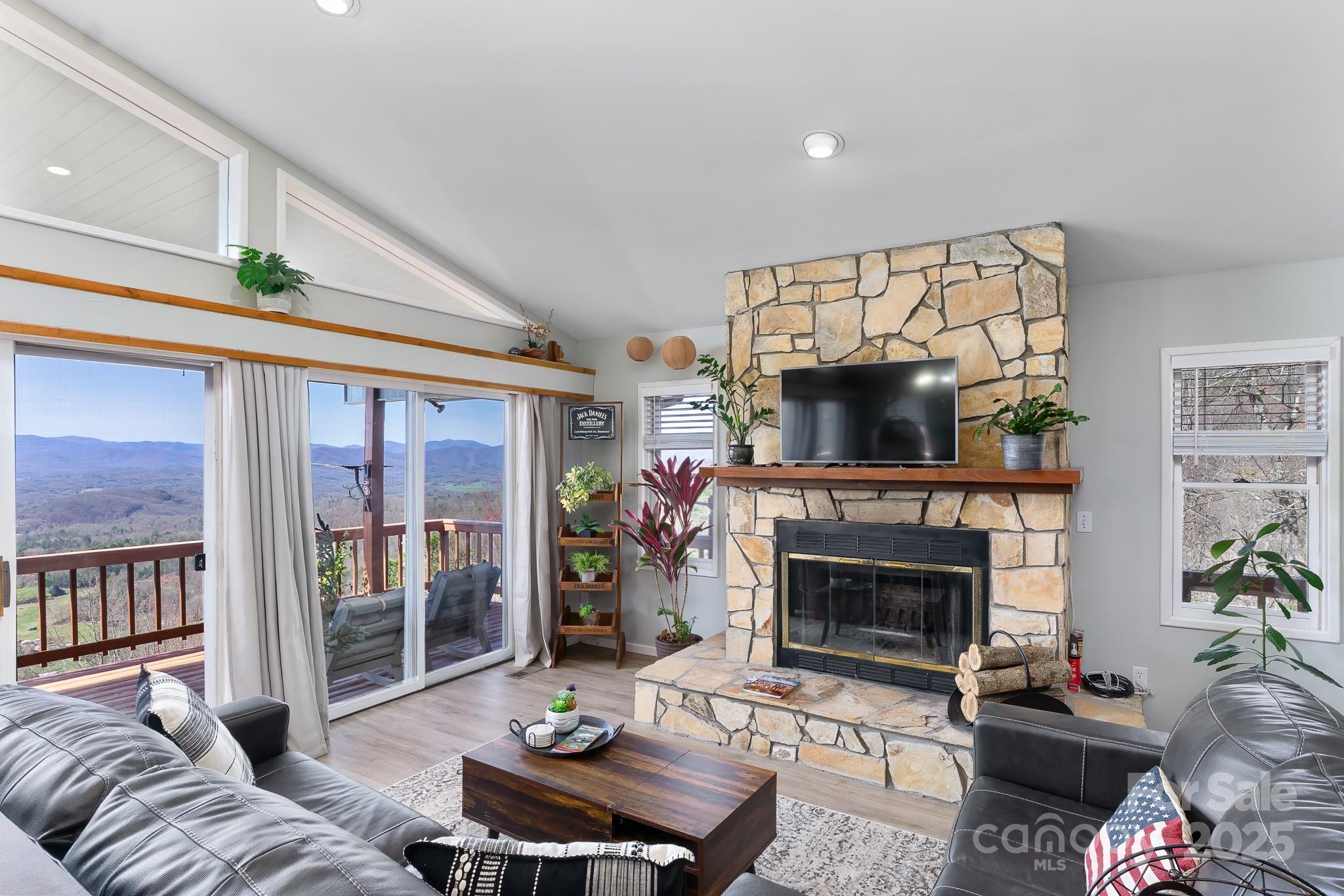 727 Chinquapin Mountain Road Franklin, NC 28734 - Photo 11 of 47 a living room with furniture a flat screen tv and a fireplace