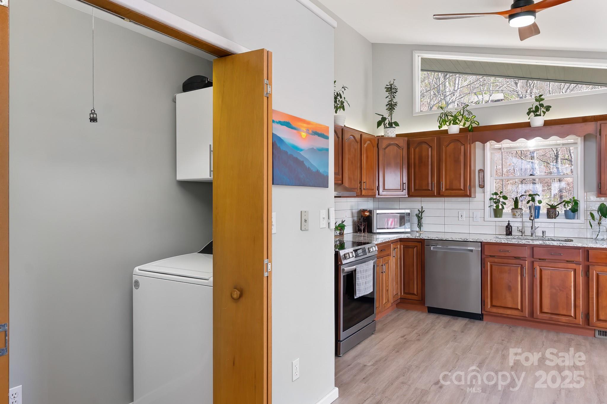 727 Chinquapin Mountain Road Franklin, NC 28734 - Photo 21 of 47 a kitchen with stainless steel appliances granite countertop a refrigerator a sink dishwasher and wooden cabinets with wooden floor