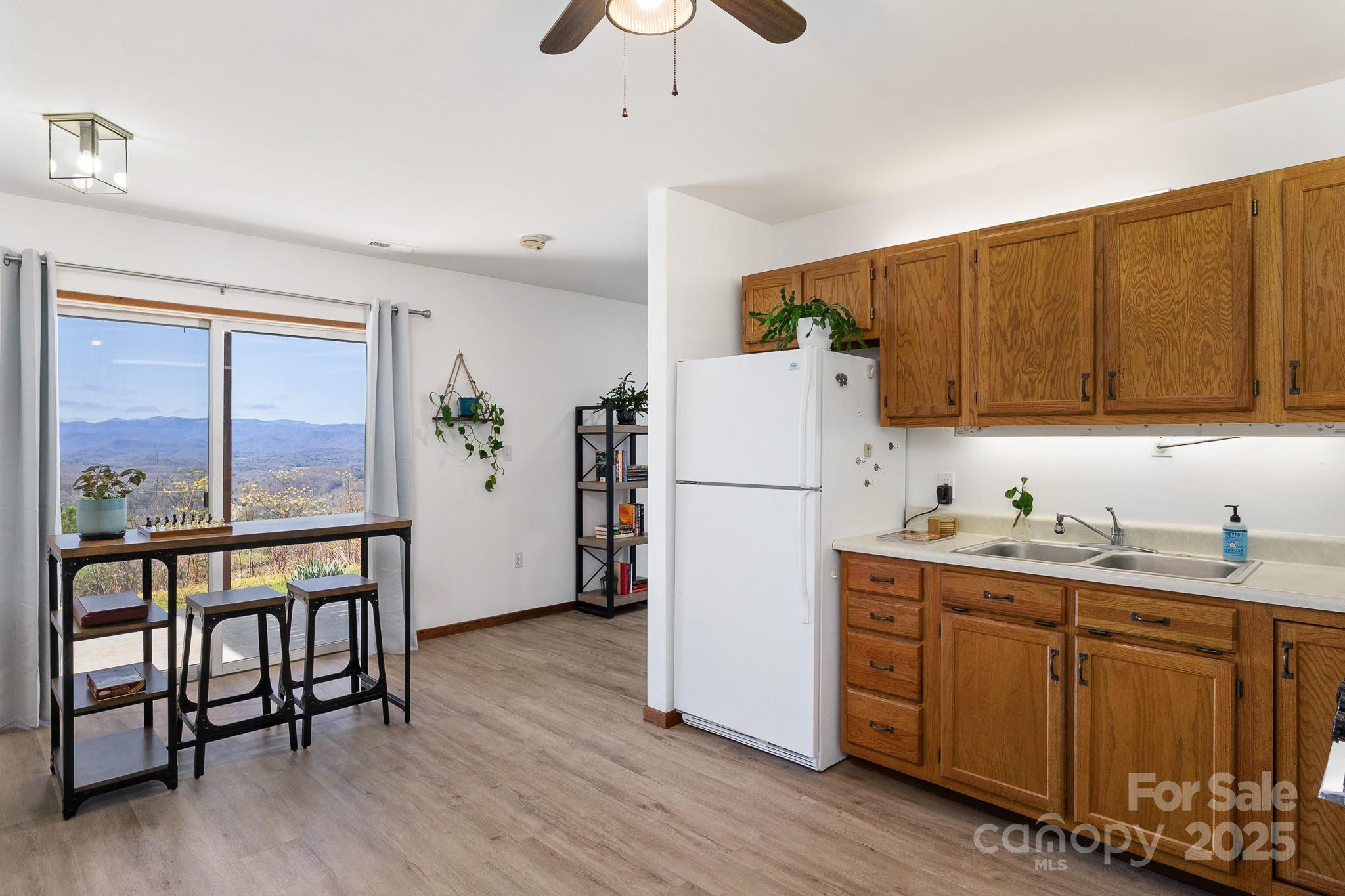 727 Chinquapin Mountain Road Franklin, NC 28734 - Photo 33 of 47 a kitchen with sink a refrigerator and wooden cabinets