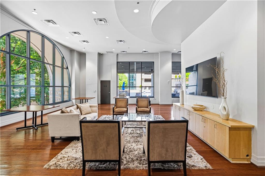 3040 Peachtree Road Northwest, Unit 1503 Atlanta, GA 30305 - Photo 31 of 38 a dining room with furniture a large window and wooden floor