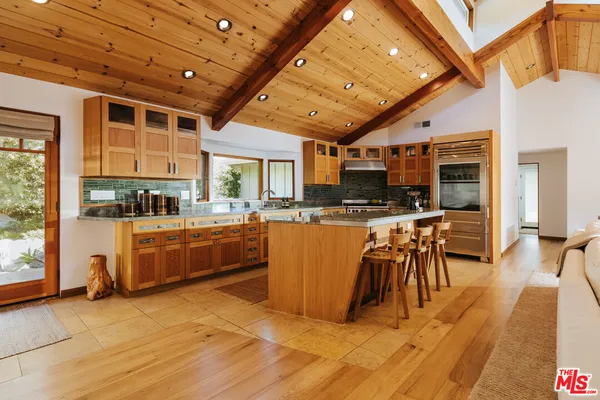 a living room with stainless steel appliances kitchen island granite countertop lots of counter top space