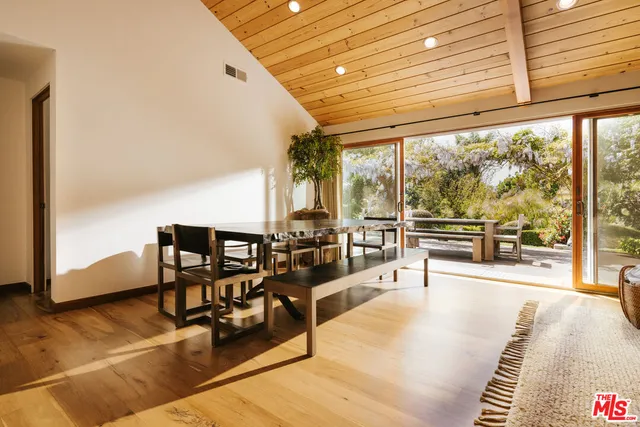 a view of a living room with furniture and floor to ceiling window