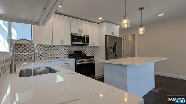 a utility room with washing machine and wooden floor
