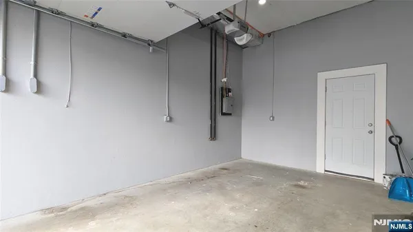 a kitchen with stainless steel appliances a dining table chairs refrigerator and microwave