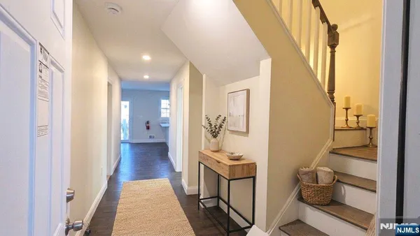 a view of a hallway with wooden floor and windows