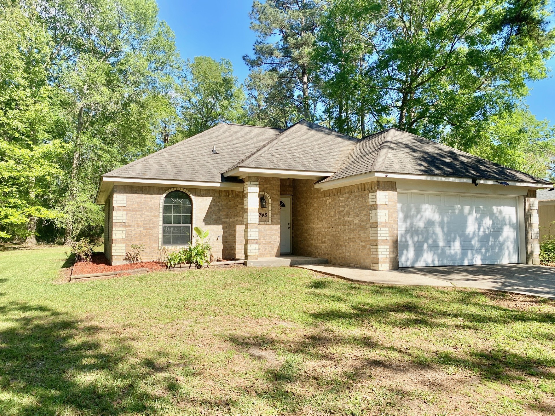 2745 Bethlehem Road Lufkin, TX 75904 - Photo 2 of 14 a house that has a big yard with plants and large trees