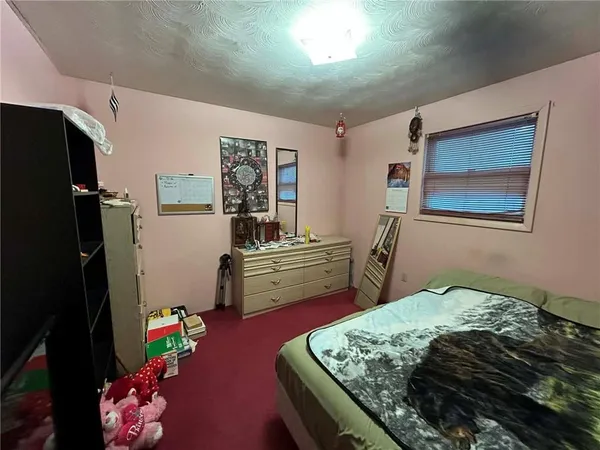 a bedroom with a bed closet and a flat tv screen