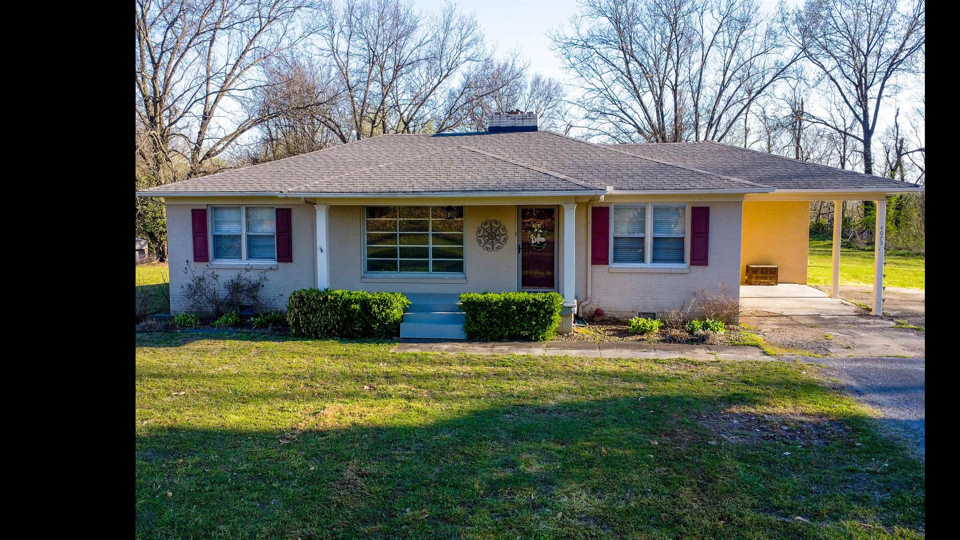 View of front of house with crawl space, a carport, a front yard, covered porch, and roof with shingles
