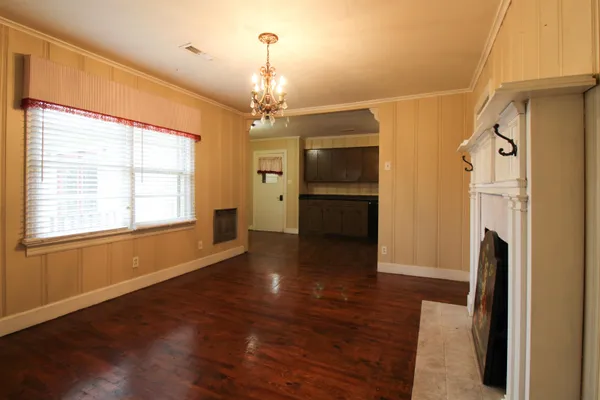 a view of a livingroom with a fireplace wooden floor and chandelier
