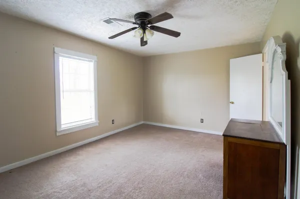 a view of a livingroom with a window and a ceiling fan