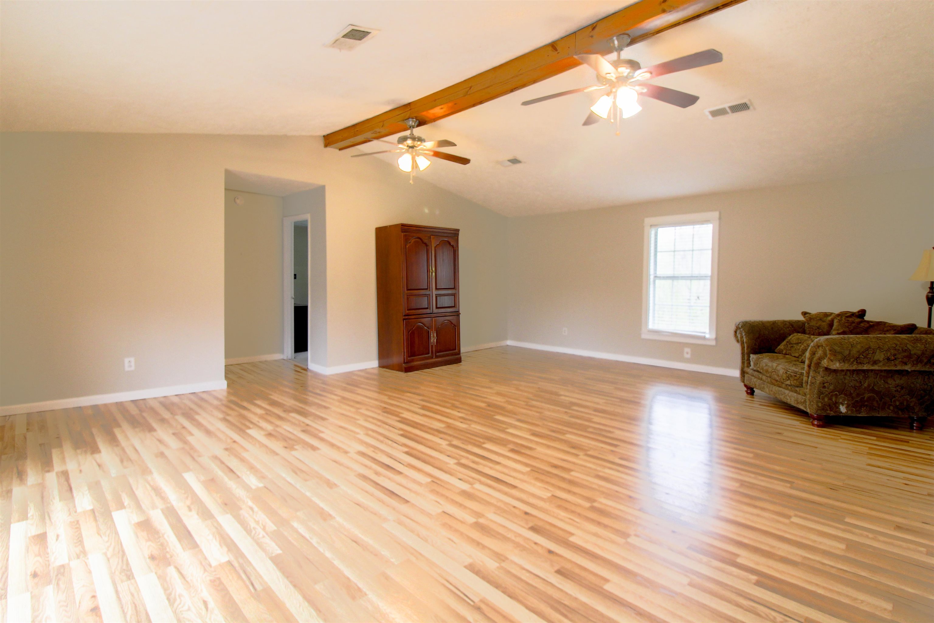 4075 Arp Central Road Ripley, TN 38063 - Photo 2 of 37 Great room with light wood-style floors, beam ceiling, and ceiling fan