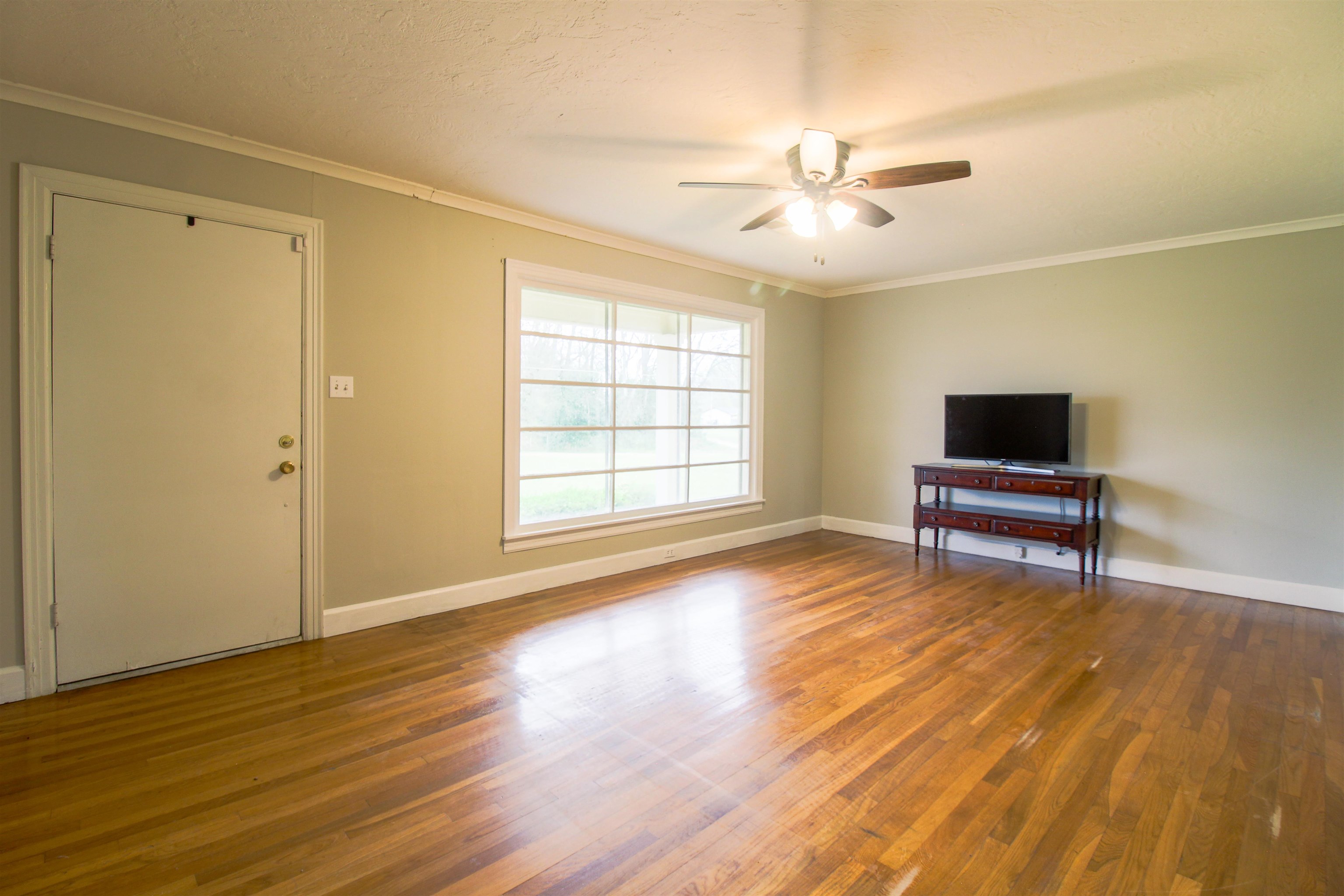 4075 Arp Central Road Ripley, TN 38063 - Photo 9 of 37 Formal Living Room with Original wood floors, ornamental molding, and ceiling fan.