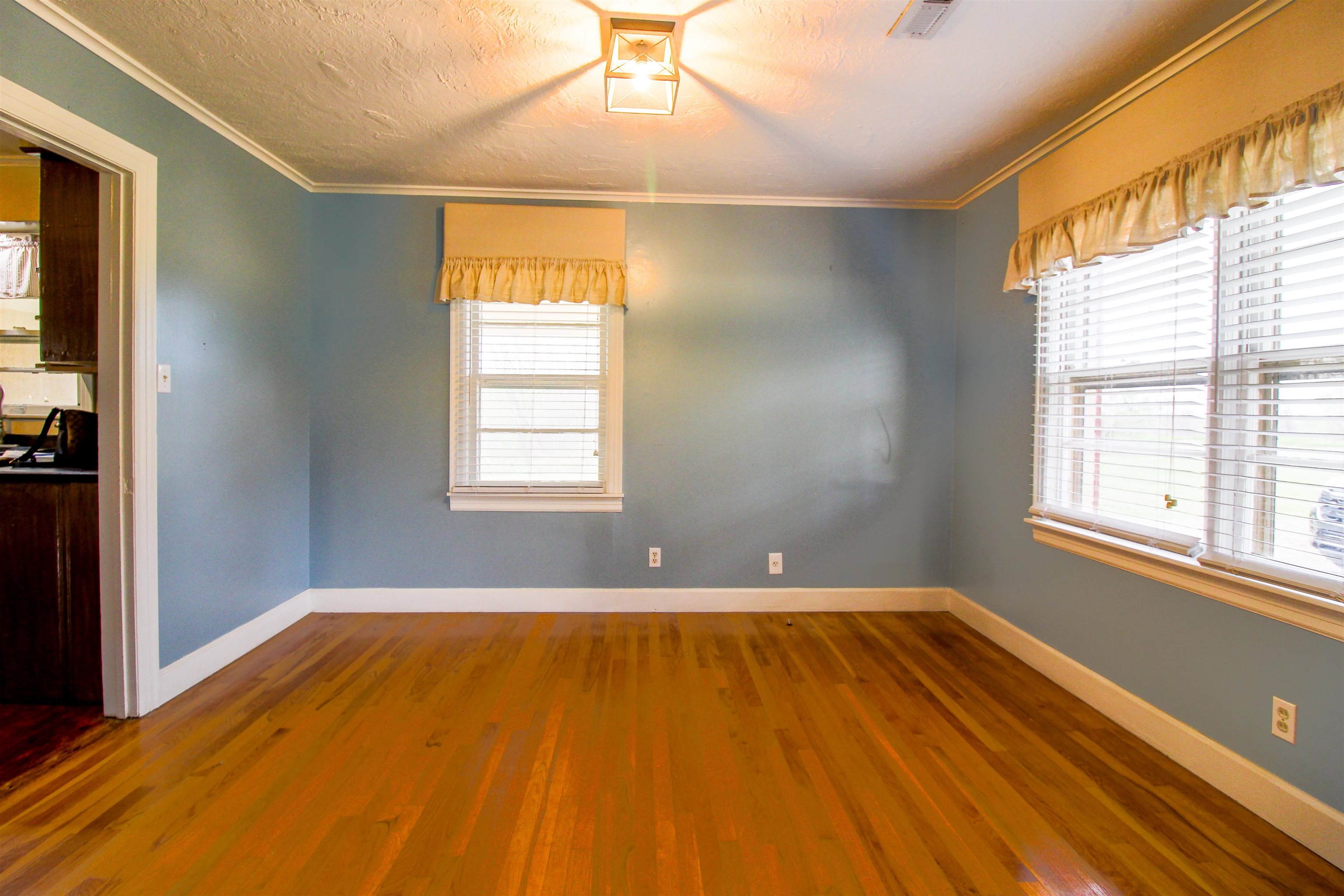 4075 Arp Central Road Ripley, TN 38063 - Photo 10 of 37 Formal Dining Room with Original Hardwood floors a textured ceiling, and ornamental molding.