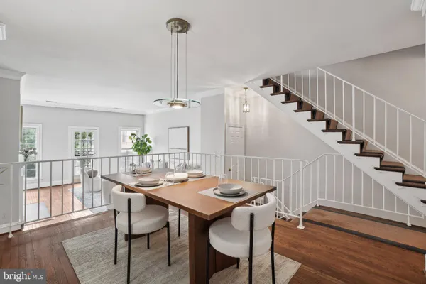 a view of a dining room and livingroom with furniture wooden floor a chandelier