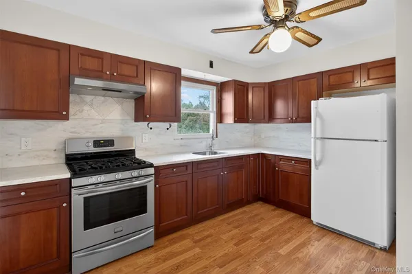a kitchen with stainless steel appliances granite countertop a stove sink and refrigerator