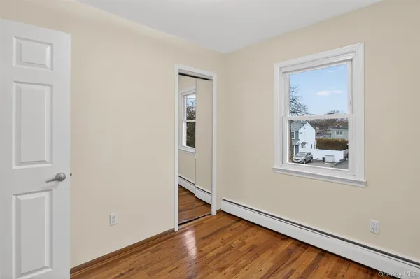 an empty room with wooden floor and a window