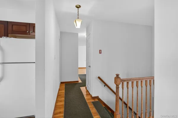 a view of a hallway with wooden floor and stairs