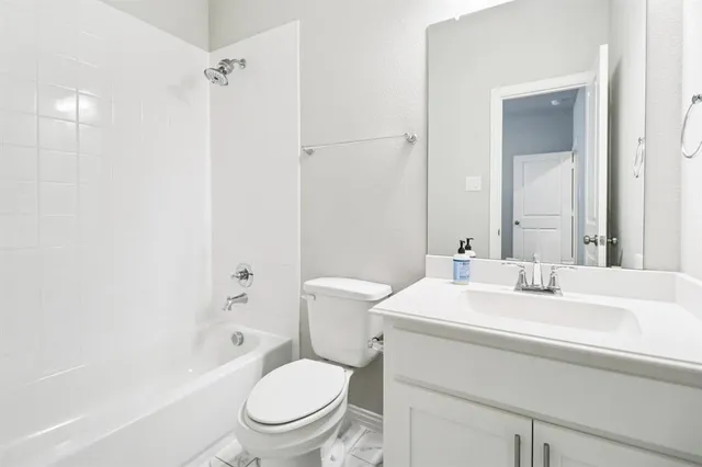 a bathroom with a sink toilet vanity and tub