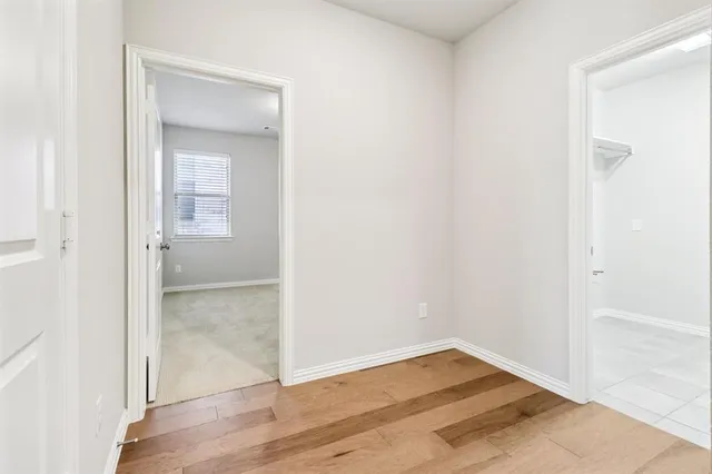 an empty room with wooden floor and mirror