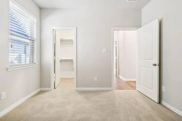 an empty room with windows and closet