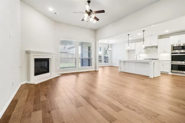 a view of kitchen with granite countertop stainless steel appliances and wooden floor