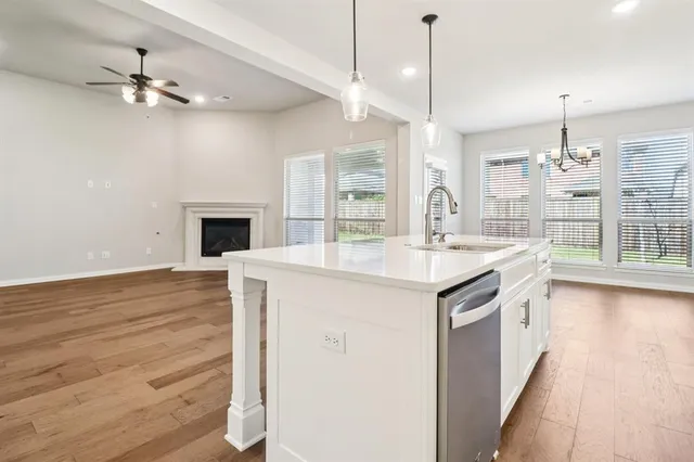 a kitchen with kitchen island granite countertop a sink appliances and cabinets