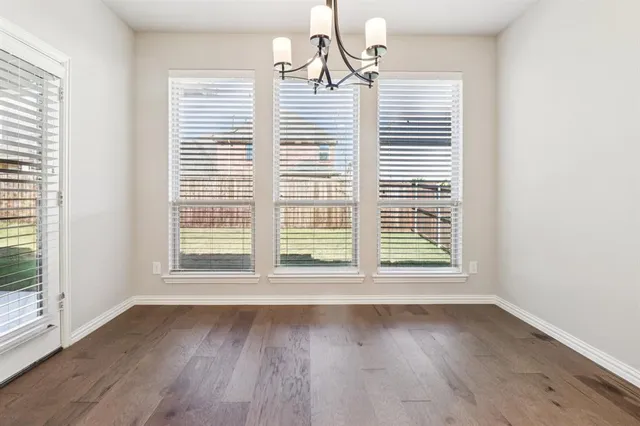 an empty room with wooden floor and a window