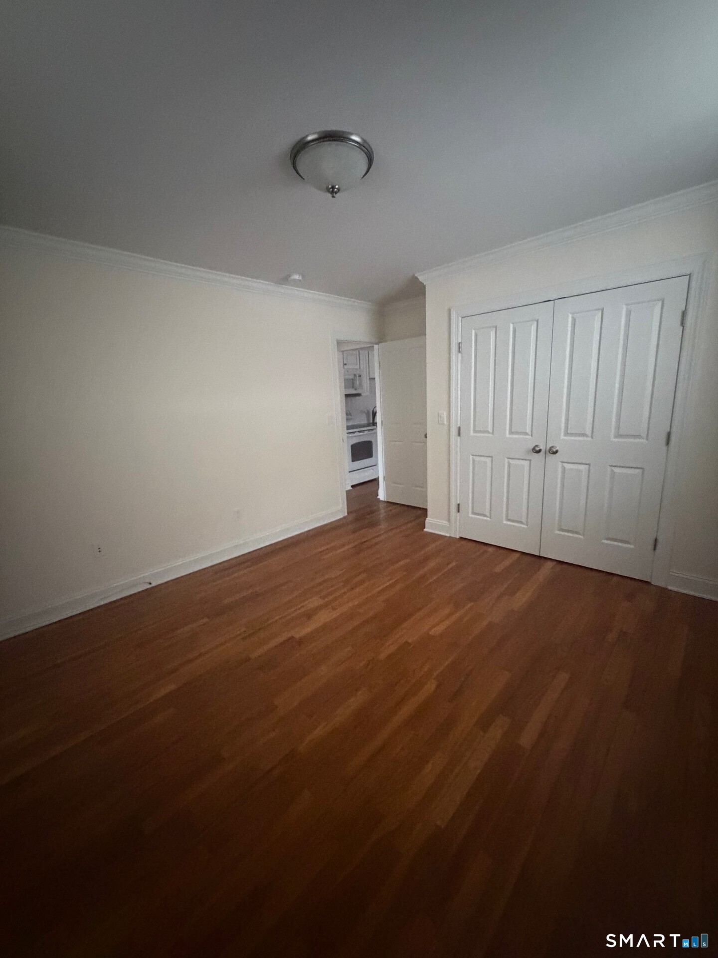 391 Reef Road, Unit 1A Fairfield, CT 06824 - Photo 13 of 24 an empty room with wooden floor and windows in it