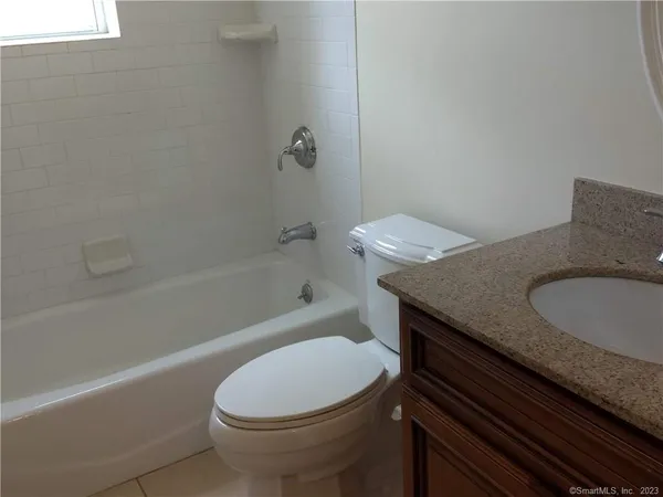 a bathroom with a granite countertop toilet sink and bathtub