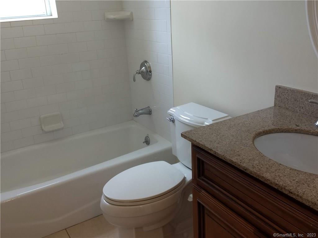 391 Reef Road, Unit 1A Fairfield, CT 06824 - Photo 8 of 24 a bathroom with a granite countertop toilet sink and bathtub