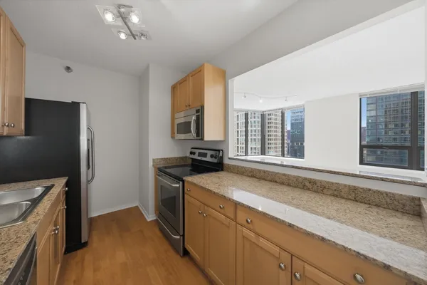 a kitchen with stainless steel appliances granite countertop a sink stove and refrigerator