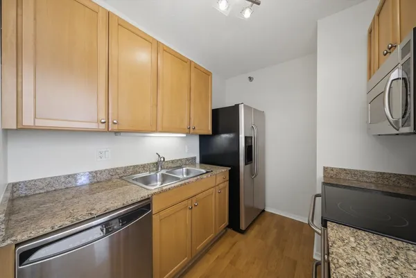 a kitchen with stainless steel appliances granite countertop a refrigerator sink and cabinets