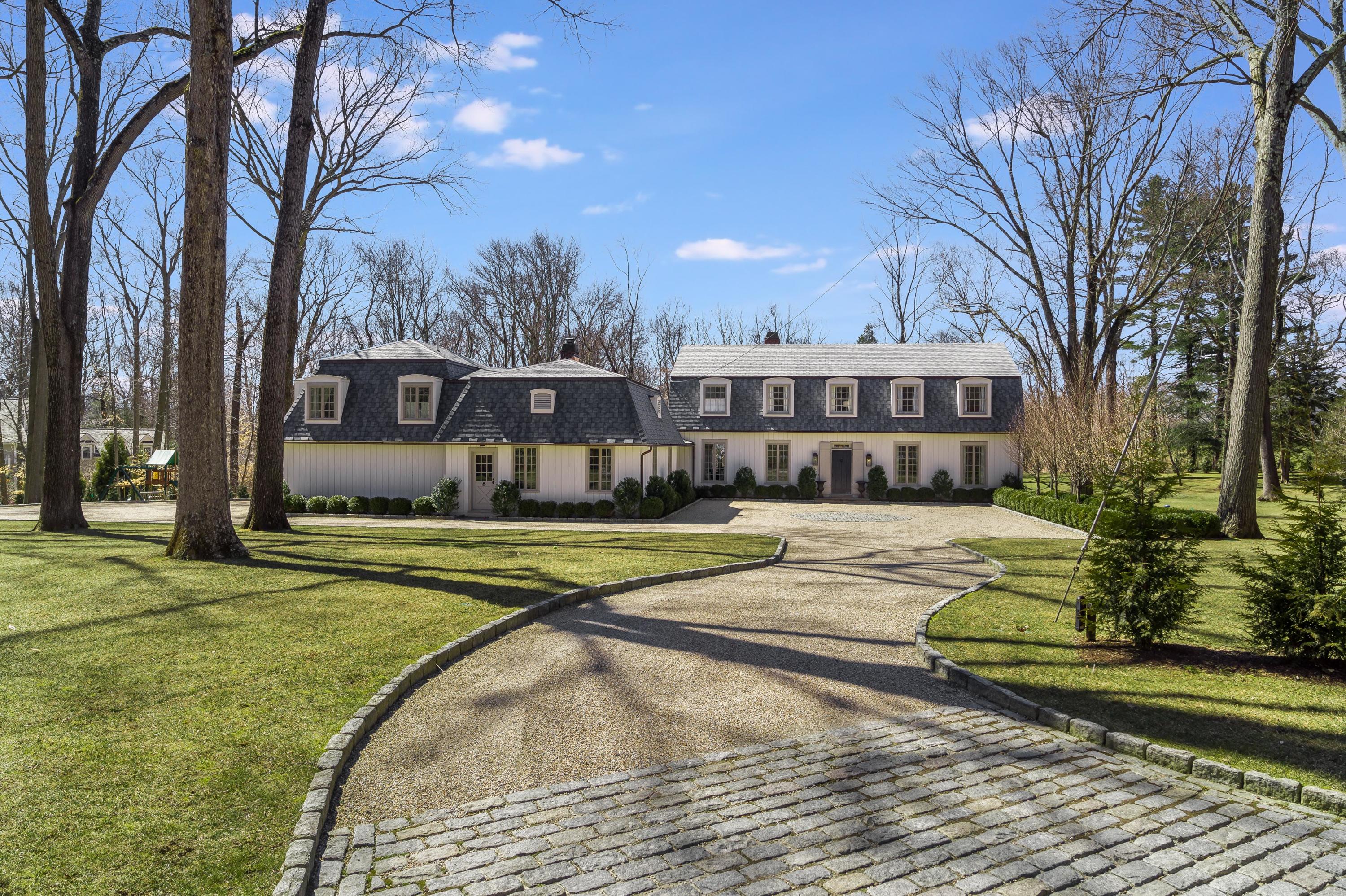 15 Indian Spring Trail Darien, CT 06820 - Photo 1 of 37 a view of a swimming pool with a house and trees in the background