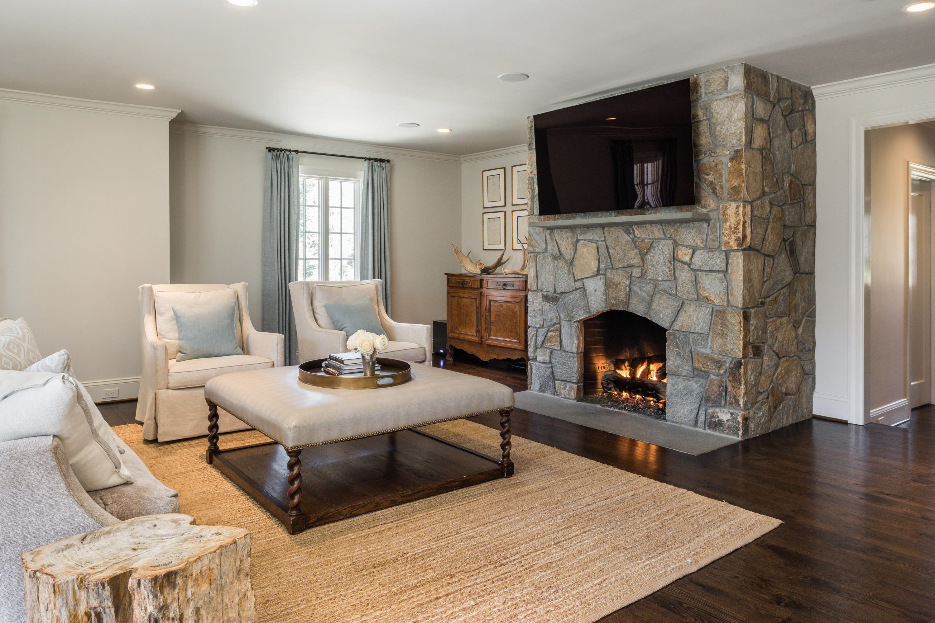 15 Indian Spring Trail Darien, CT 06820 - Photo 18 of 37 a living room with furniture a fireplace and a flat screen tv