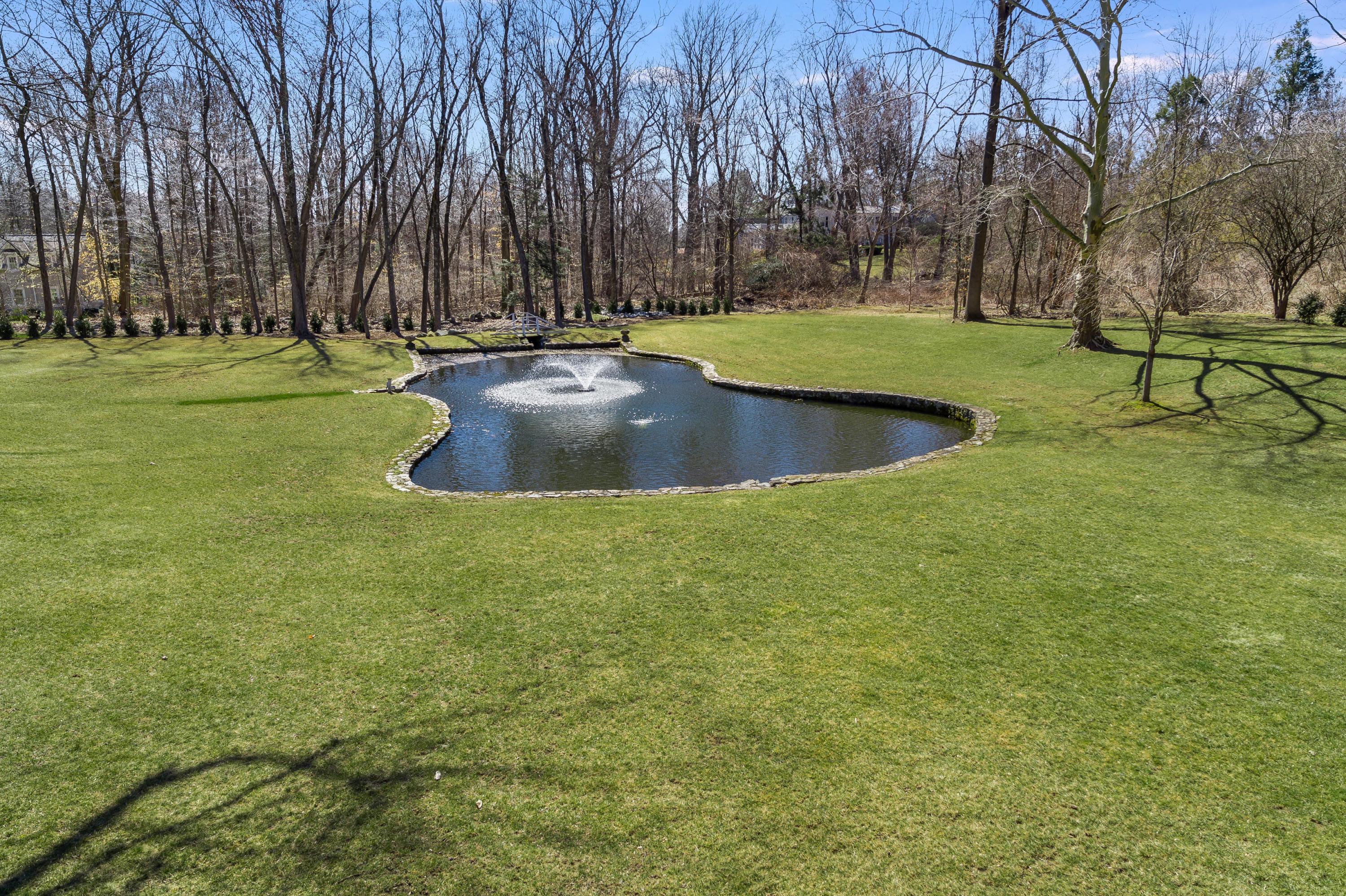 15 Indian Spring Trail Darien, CT 06820 - Photo 7 of 37 a view of a swimming pool with a yard and trees