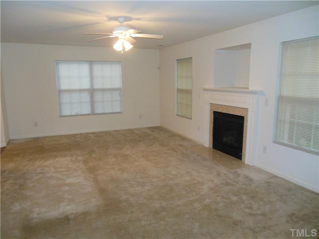 2046 Spring Creek Drive Durham, NC 27704 - Photo 4 of 10 an empty room with chandelier fan and windows