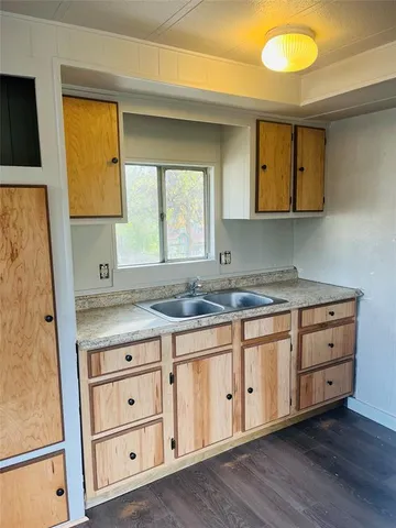 a kitchen with granite countertop a sink and a stove with wooden floor