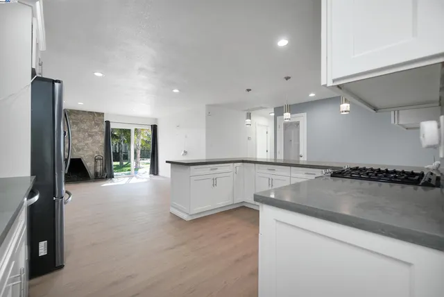 a large kitchen with stainless steel appliances granite countertop a stove a sink and a refrigerator