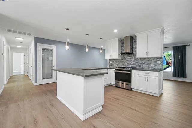 a kitchen with kitchen island stainless steel appliances a refrigerator and a sink