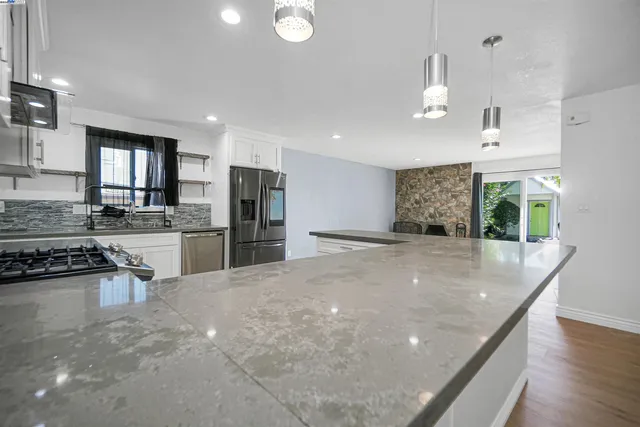 a kitchen with granite countertop white cabinets and white appliances