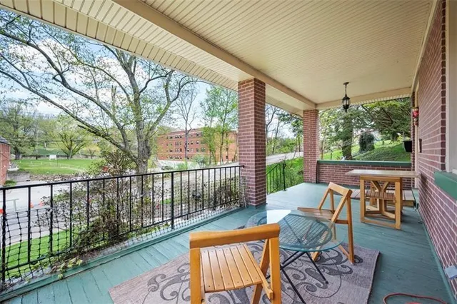 a view of a patio with a table and chairs and a large tree
