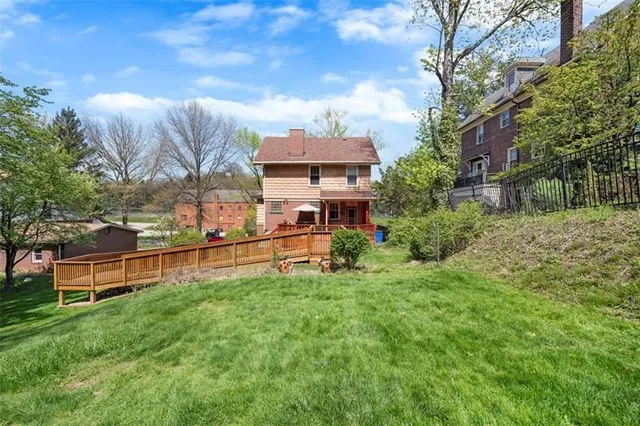 an aerial view of residential house with outdoor space and trees all around