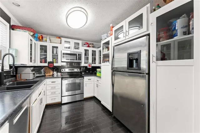 a kitchen with stainless steel appliances granite countertop a stove a sink and a microwave