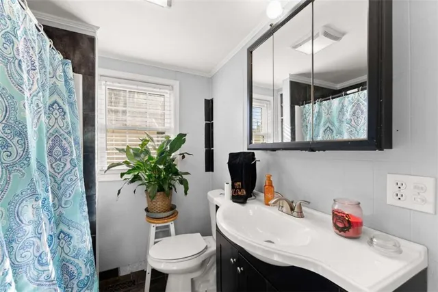 a bathroom with a sink toilet and a mirror