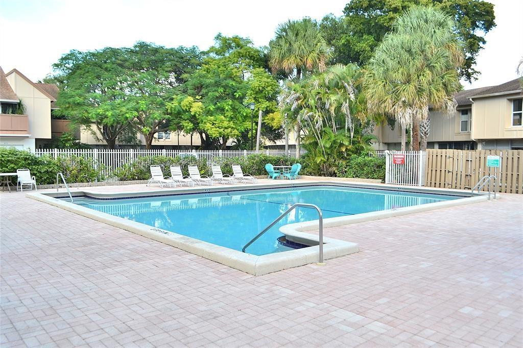 8237 Northwest 8th Court, Unit 4 Plantation, FL 33324 - Photo 23 of 24 a swimming pool with outdoor seating and yard