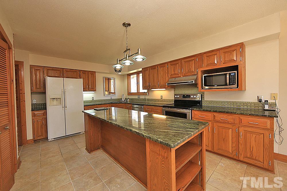 11716 Appaloosa Run East Raleigh, NC 27613 - Photo 7 of 30 Large kitchen with island, granite countertops and glass tile backsplash.