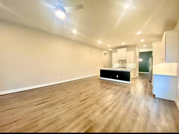a view of empty room with wooden floor and fireplace
