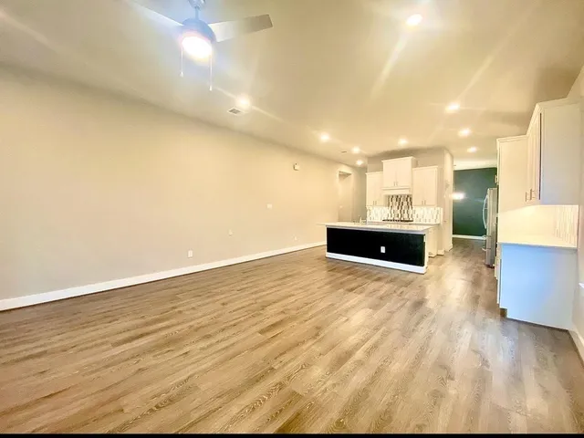a view of empty room with wooden floor and fireplace
