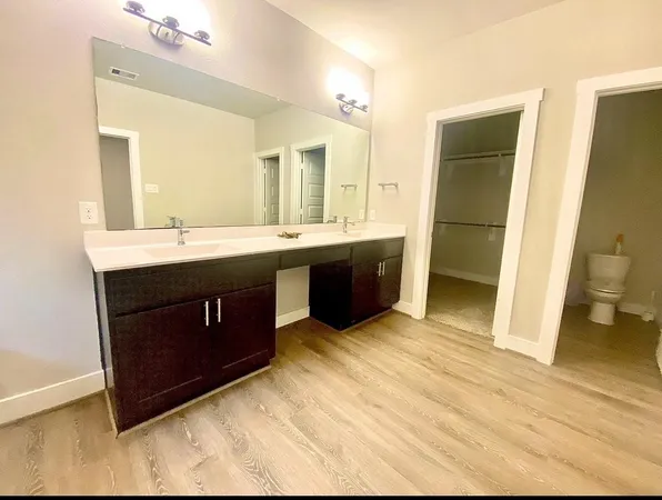 a spacious bathroom with a granite countertop sink a toilet and shower